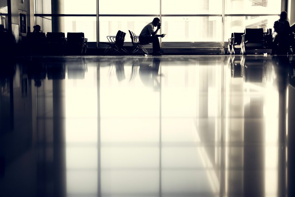 man in departure lounge using skype for business